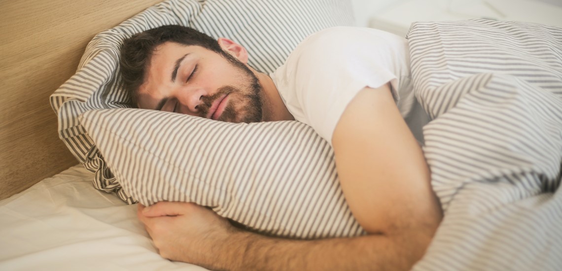 man sleeping comfortably in bed with air conditioner running